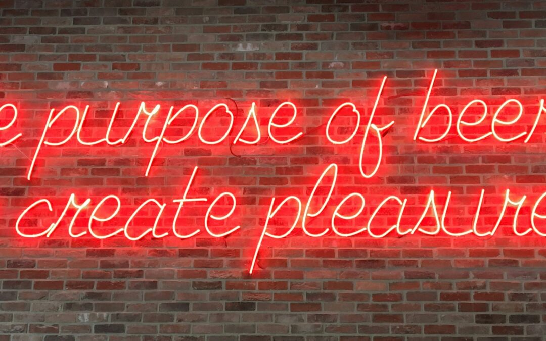 Neon sign that reads "The purpose of beer is to create pleasure"