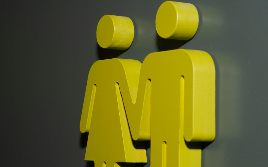 Yellow male and female icons on a concrete wall