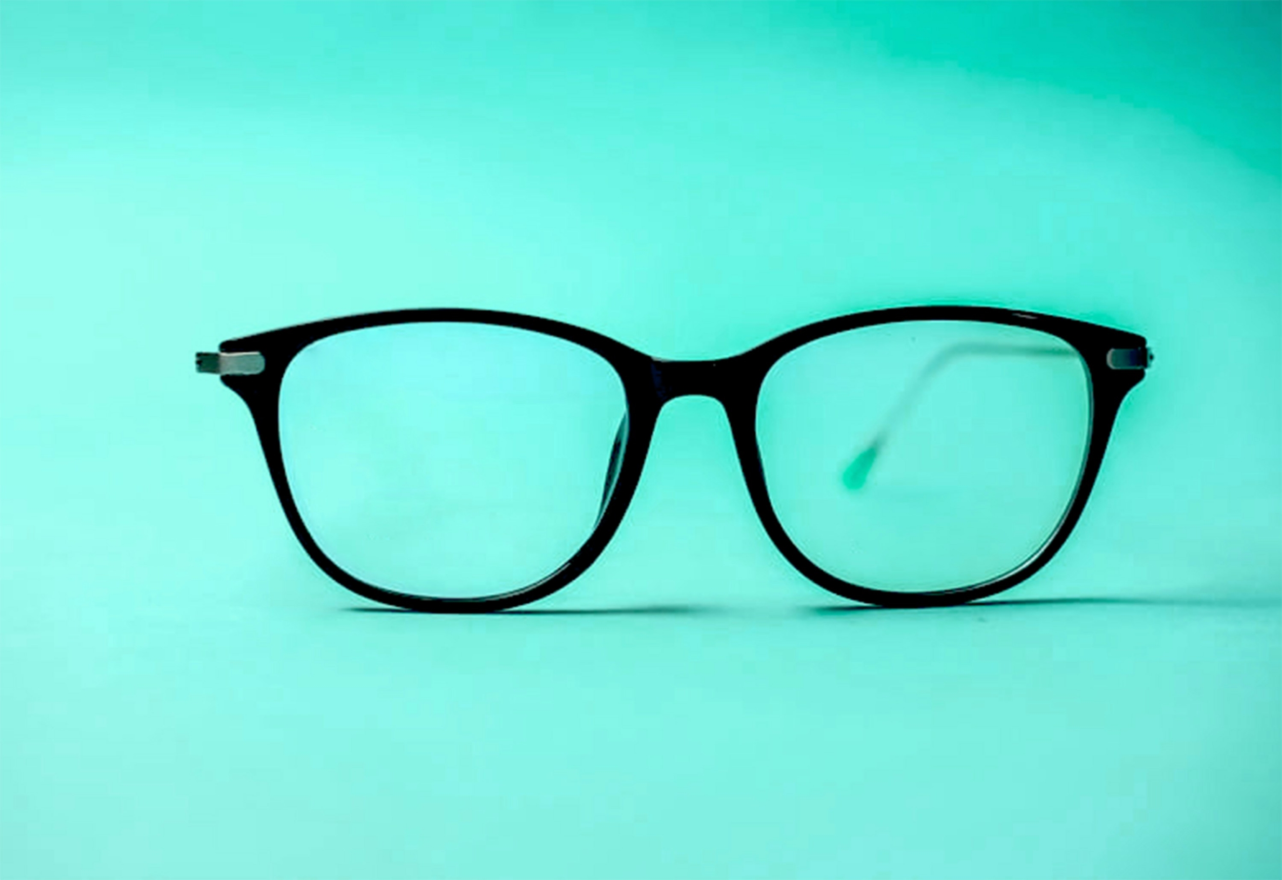 black glasses on a teal background